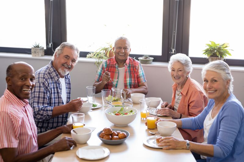 Portrait of senior people having breakfast at table in nursing home