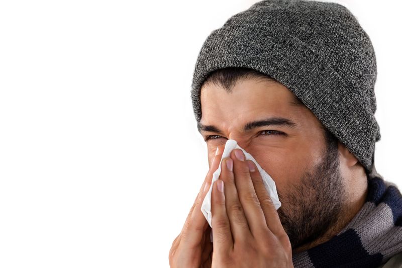 Man blowing his nose with tissue paper