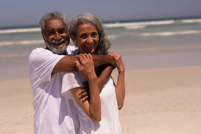 Senior man embracing senior woman on beach