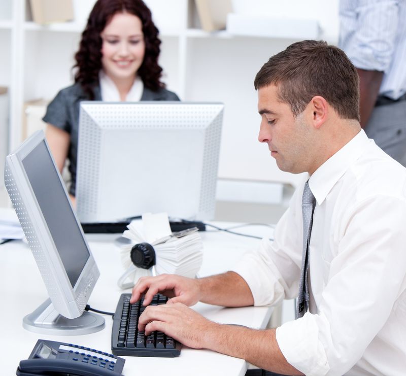 Assertive young business people working at computers in the office