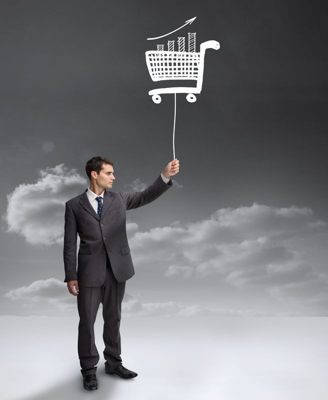 Businessman holding a floating shopping cart