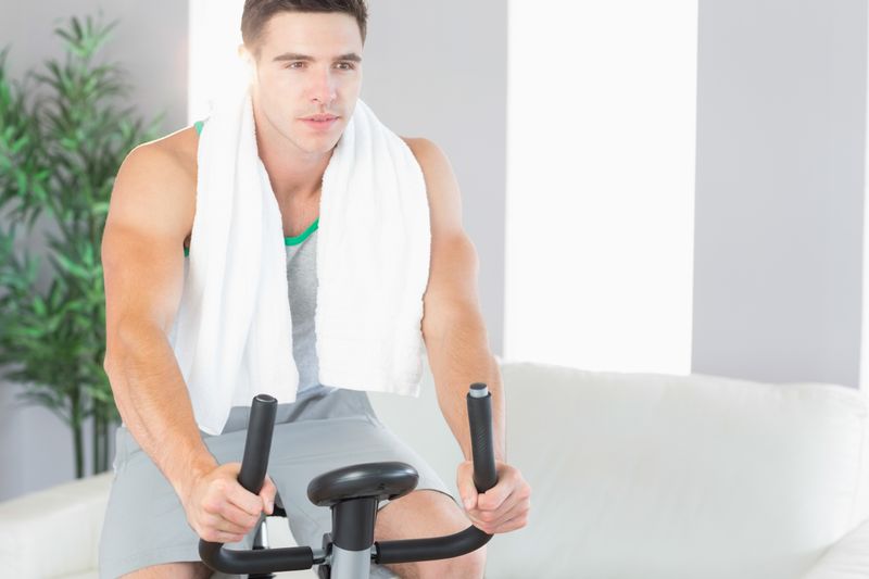 Determined handsome man exercising on exercise bike