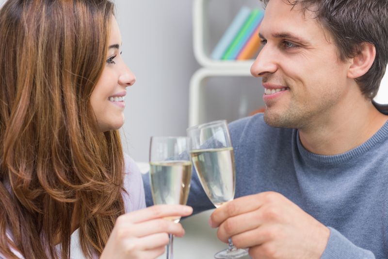 Closeup of a smiling young couple toasting flutes