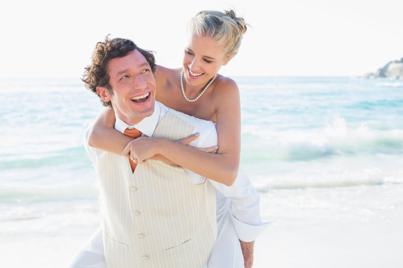 Smiling bride getting a piggy back from new husband