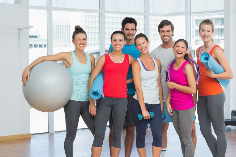 Portrait of fit young people smiling in a bright exercise room