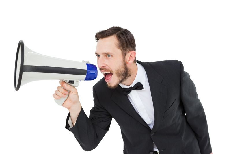 Geeky businessman shouting through megaphone