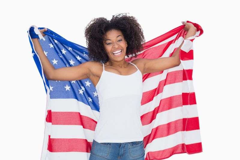 Pretty girl holding american flag cheering at camera