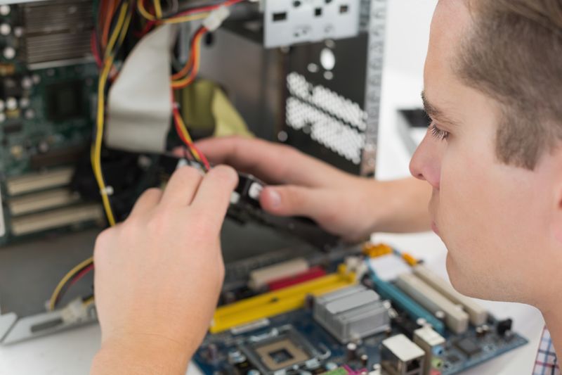 Young technician working on broken computer