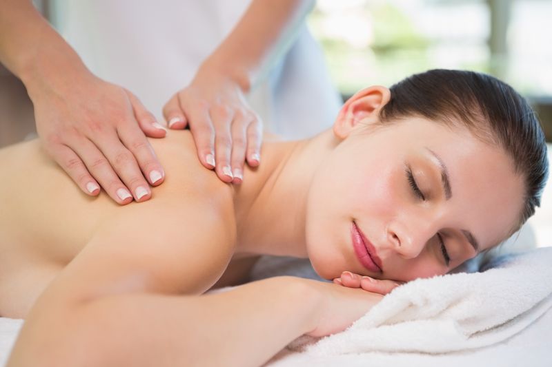 Attractive woman receiving shoulder massage at spa center