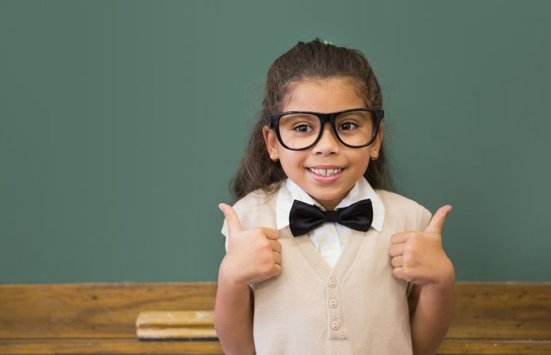 Cute pupil dressed up as teacher in classroom