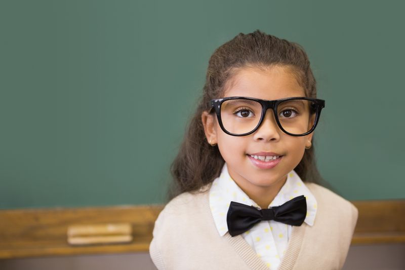 Cute pupil dressed up as teacher in classroom