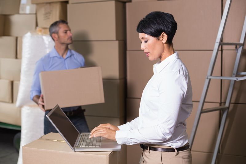 Pretty warehouse manager using laptop