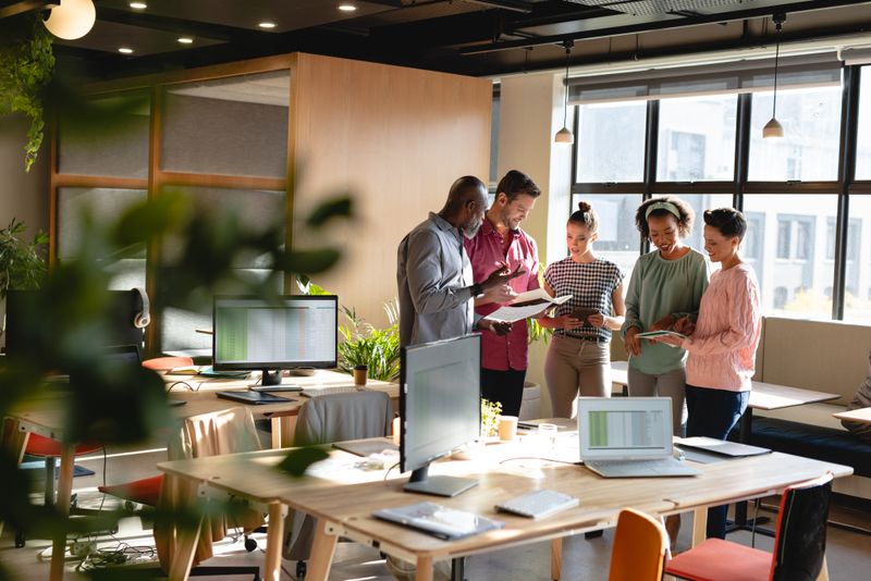 Multiracial male and female colleagues discussing business plan during meeting in creative office. Unaltered, creative business, workplace, meeting, strategy, teamwork, diversity.