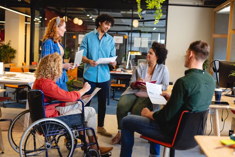 Multiracial businesswomen and businesswomen discussing strategy in meeting at office. Unaltered, creative business, workplace, meeting, disability, support, diversity, teamwork.