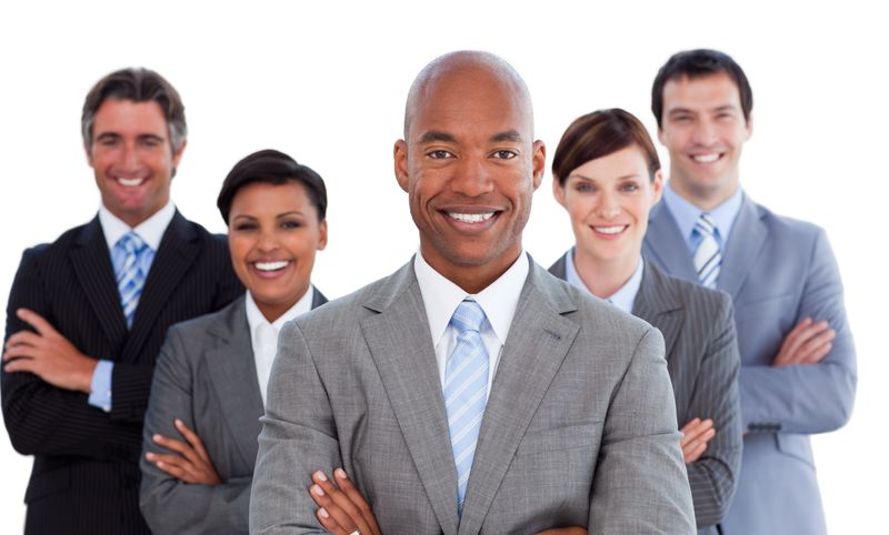 Smiling business people looking at the camera against a white background