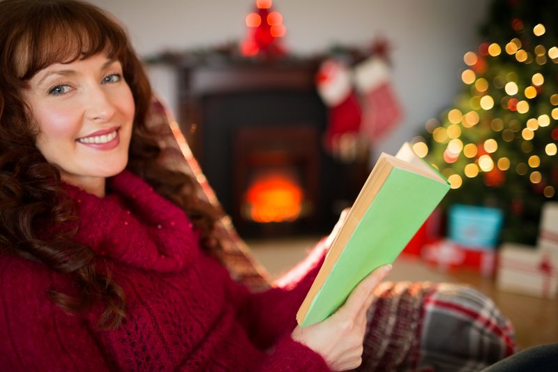 Smiling red hair reading on the couch at christmas