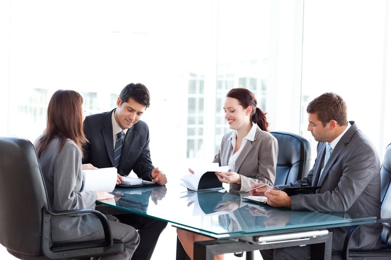 Four business people during a meeting sitting around a table 