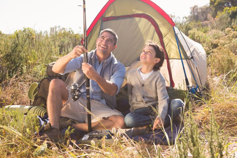 Father and son beside their tent in the countryside 