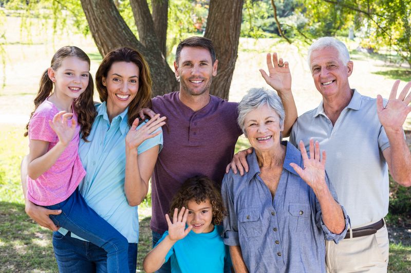 Extended family smiling in the park