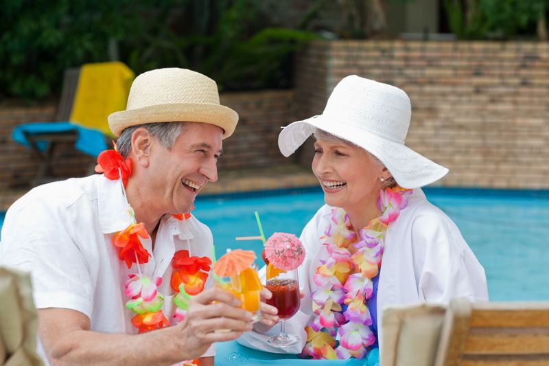 Happy senior couple drinking cocktails and toasting each other 