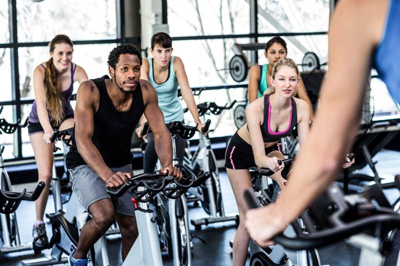 Fit people working out at spinning class in the gym