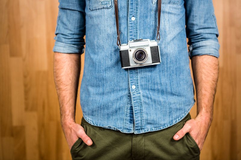 Hipster man holding digital camera