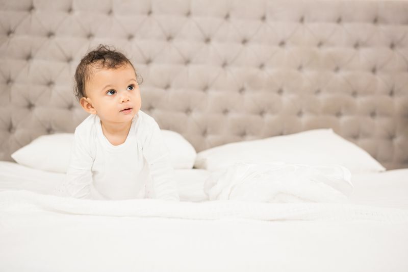 Cute baby sitting on bed