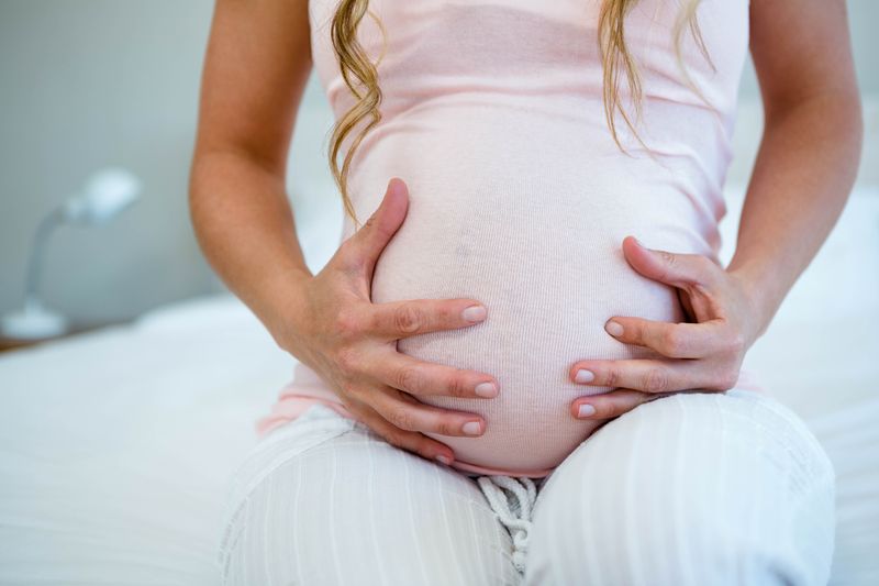 pregnant woman holding her bump