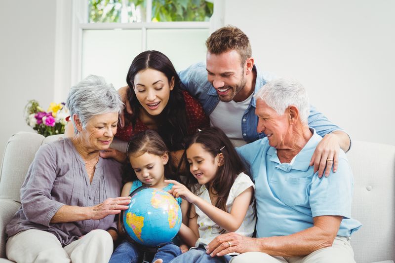 Family on sofa looking at terrestrial globe