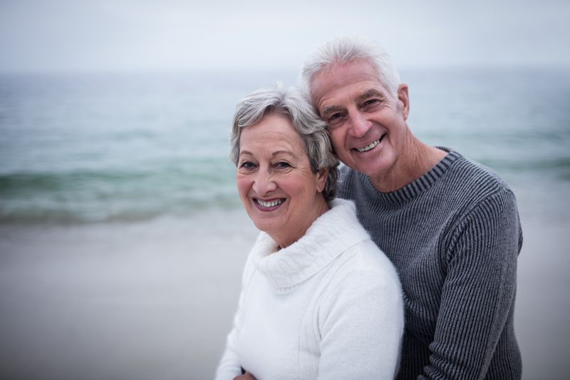 Happy senior couple embracing each other on the beach