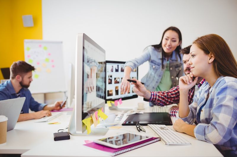 Business people working with computers at desk in creative office