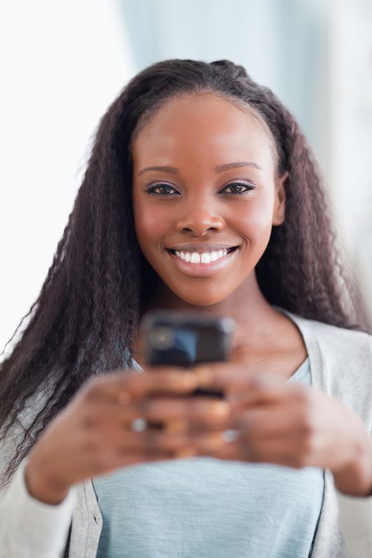 Close up of smiling woman holding smartphone