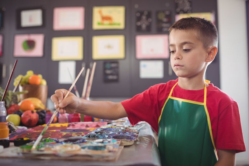 Boy painting at desk