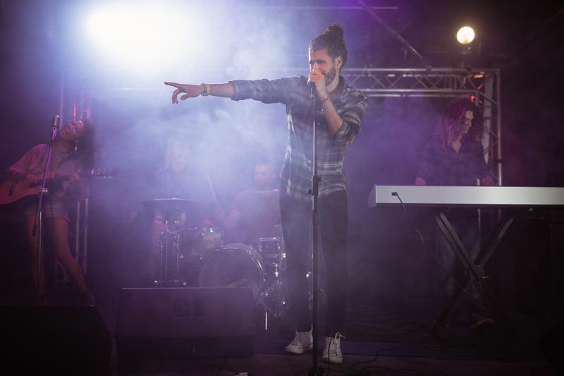 Male singer performing on stage during music festival