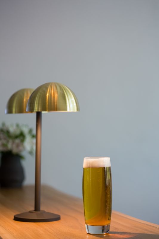Close up of beer glass by lamp in restaurant