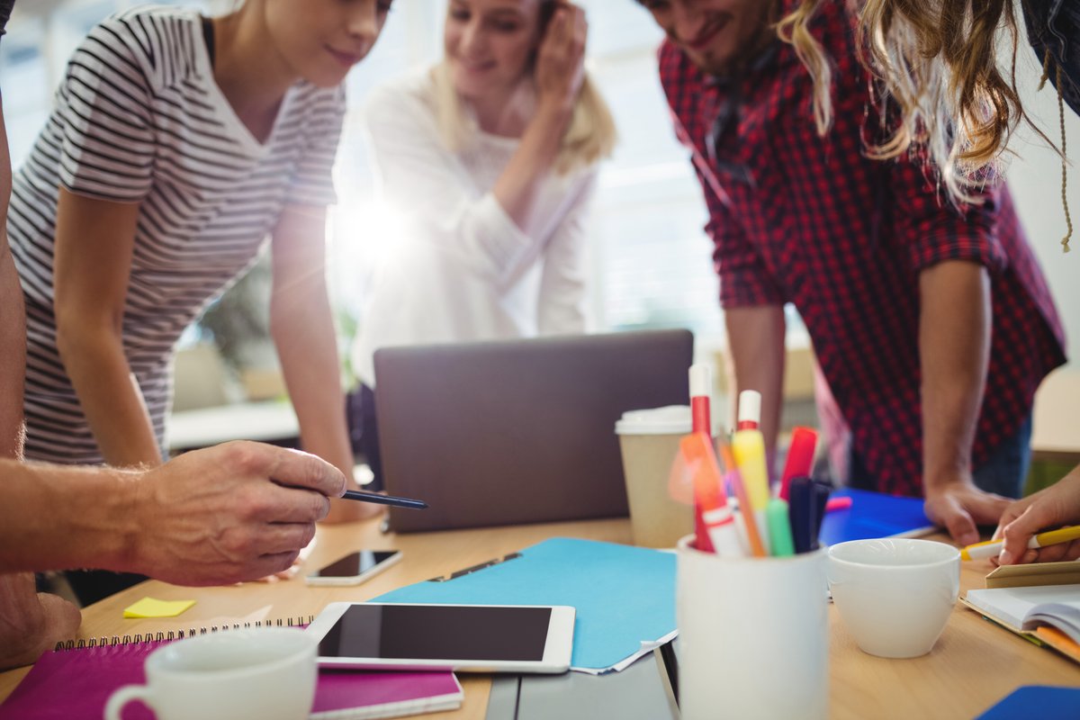 Colleagues are standing at the table and discussing a project - A way to understand your audience - Image
