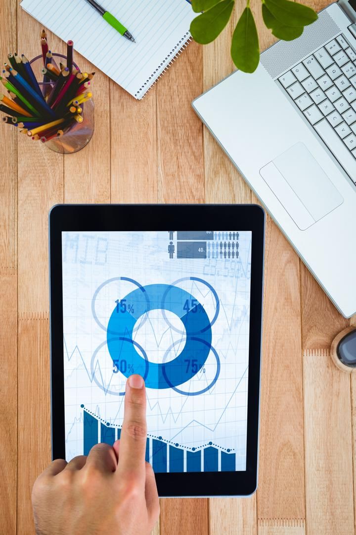 Tablet with data on a wooden desk with a notebook and pencils - How to create engaging content for blogs - Image