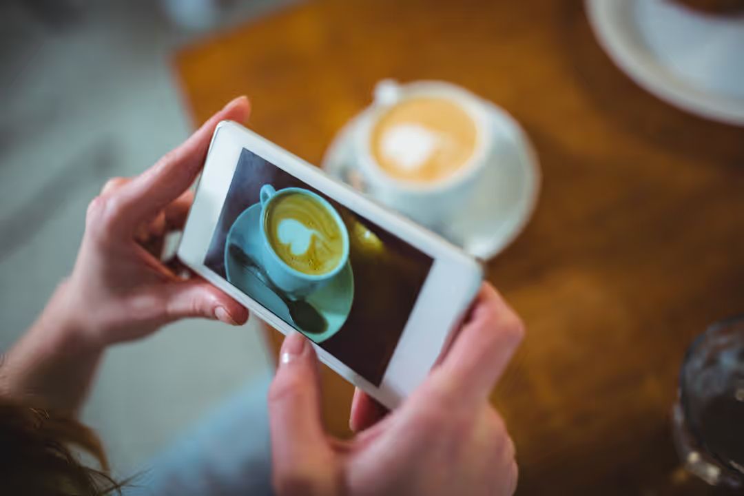 Image of a person who is taking a picture of her coffee with her smartphone - Everything you need to know about image copyright - Image