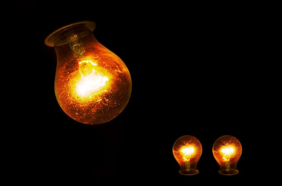 An image of three light bulbs glowing in the dark - Educate your customers through social media posts - Image