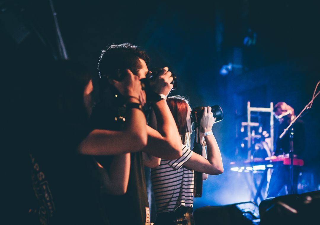 Photographers taking photos of a live concert - Quality social media visuals are always worth the effort - Image