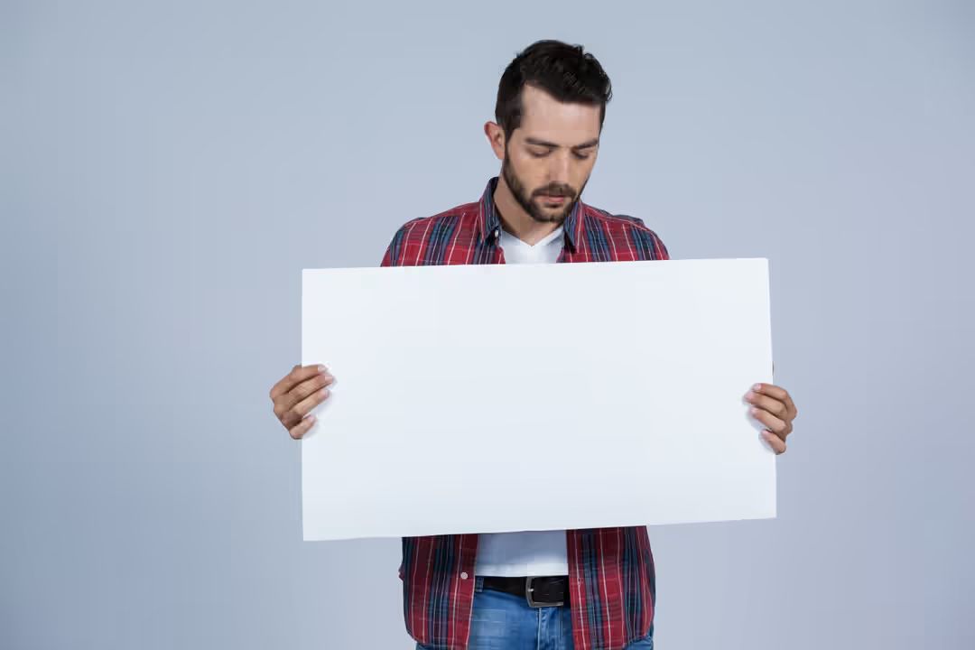 Man wearing casual clothes holding a large blank white card - Simple but powerful tactics for crafting compelling ad copies that drive sales - Image