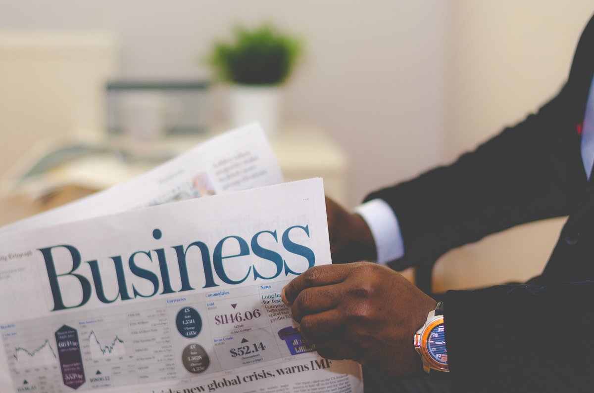 Image of a man holding a business newspaper - A practical guide on how to get the most out of your writing if you're planning on starting a money blog - Image