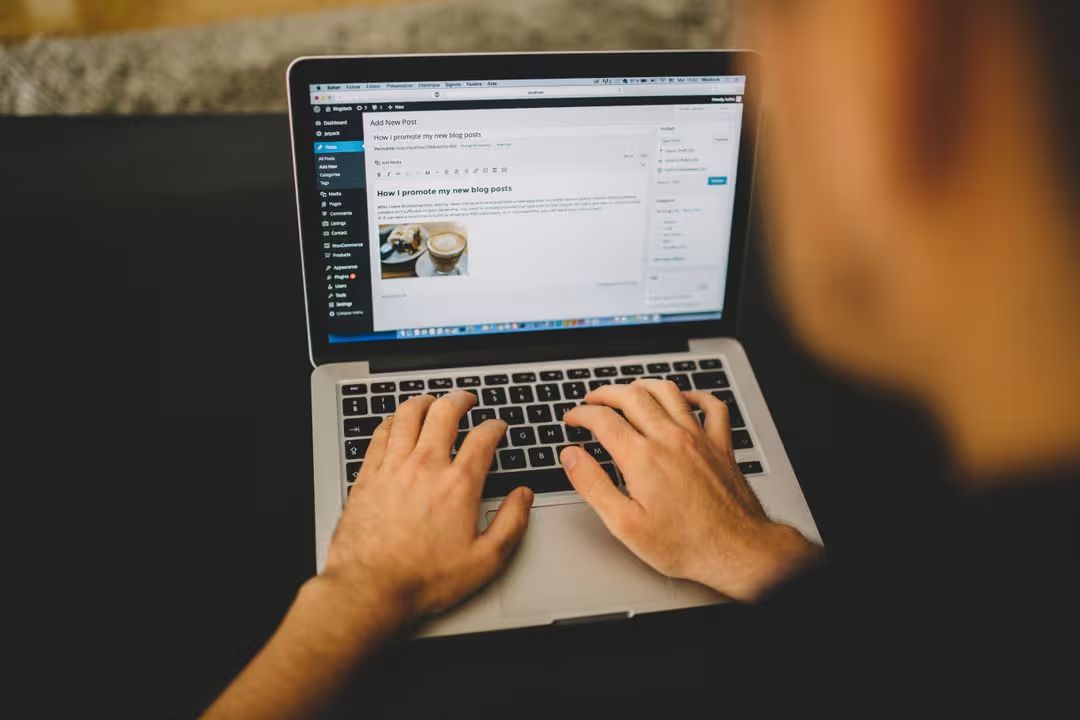 Behind image of a blogger writing their copy on wordpress on a laptop - Simple but powerful tactics for crafting compelling ad copies that drive sales - Image
