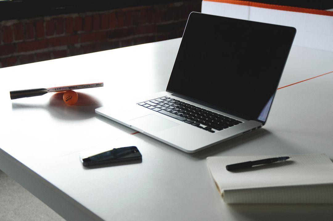 Image of a laptop on a desk with notebook and pen - Must-know design tips for using images on websites - Image