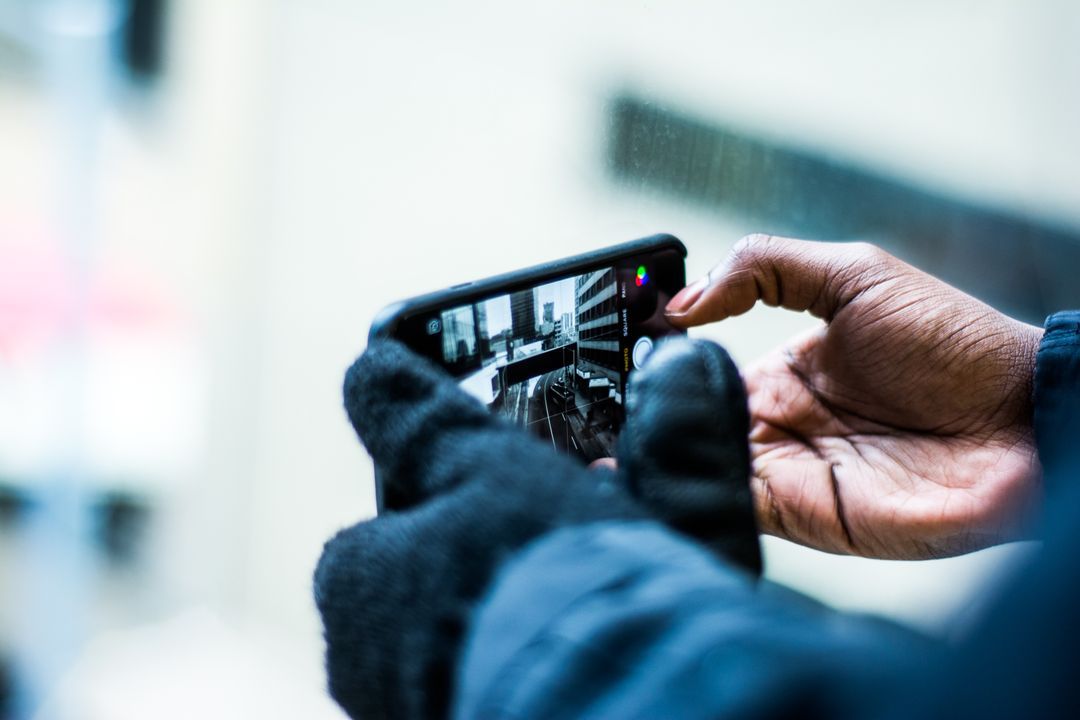 Close up of person's hands taking a photo with smartphone - 15 essential graphic design tips from the experts for industry beginners - Image