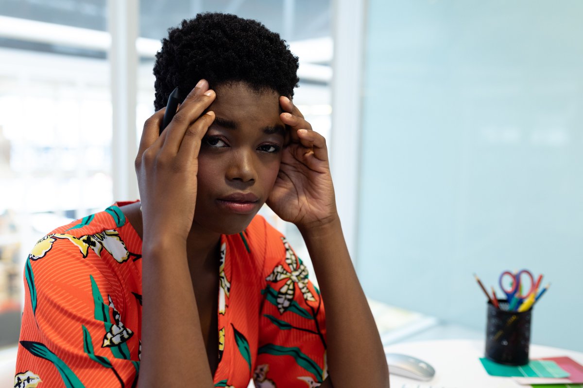 Image of a woman sitting at a desk with her hands on her head - Reevaluate your social media strategy - Image