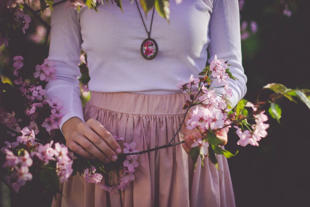 Image of woman wearing pink holding pink flowers with green leaves - How to choose a good color combination for photography - Image