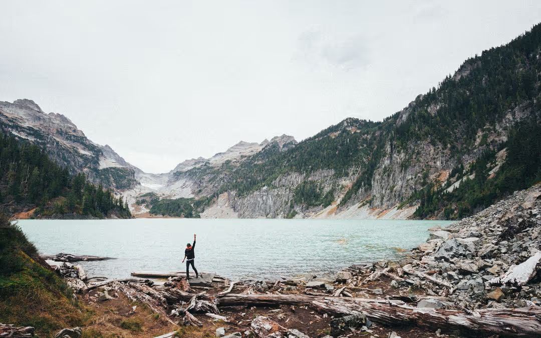 Image of a man at a lake with mountain range in the background - Meaning and use of hero image in web design - Image