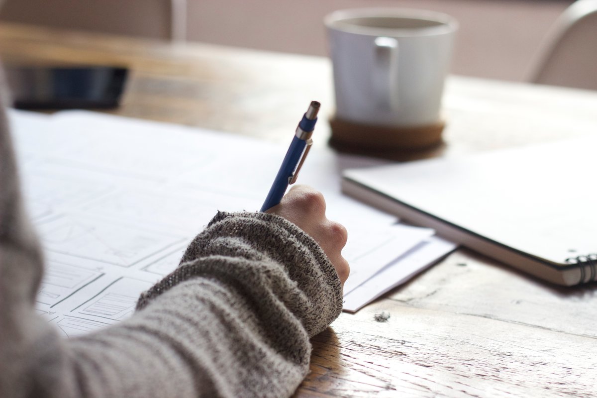 Image of a person writing with a pen - A beginner's guide to royalty-free content - Image