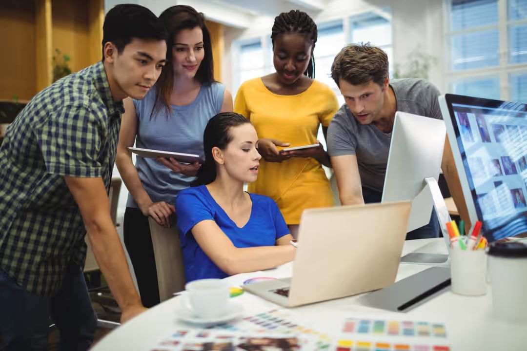 Graphic designers discussing over laptop - Why you should use solid examples for your social media content if you want to grow your audience - Image